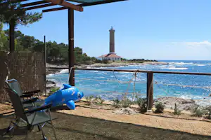 Camp Kargita - überdachter Wohnwagen- und Zeltstellplatz vom Campingplatz mit Blick auf den Leuchtturm und das Mittelmeer