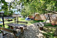 Camp Stara Pošta - Weg zu den Waldhütten im Schatten der Bäume auf dem Campingplatz