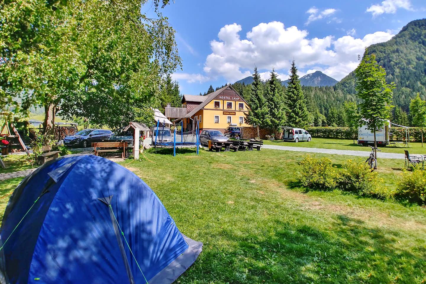 Camp Stara Pošta -  Campingbereich für Zelte und Wohnwagen im Schatten der Bäume mit Blick auf die Berge