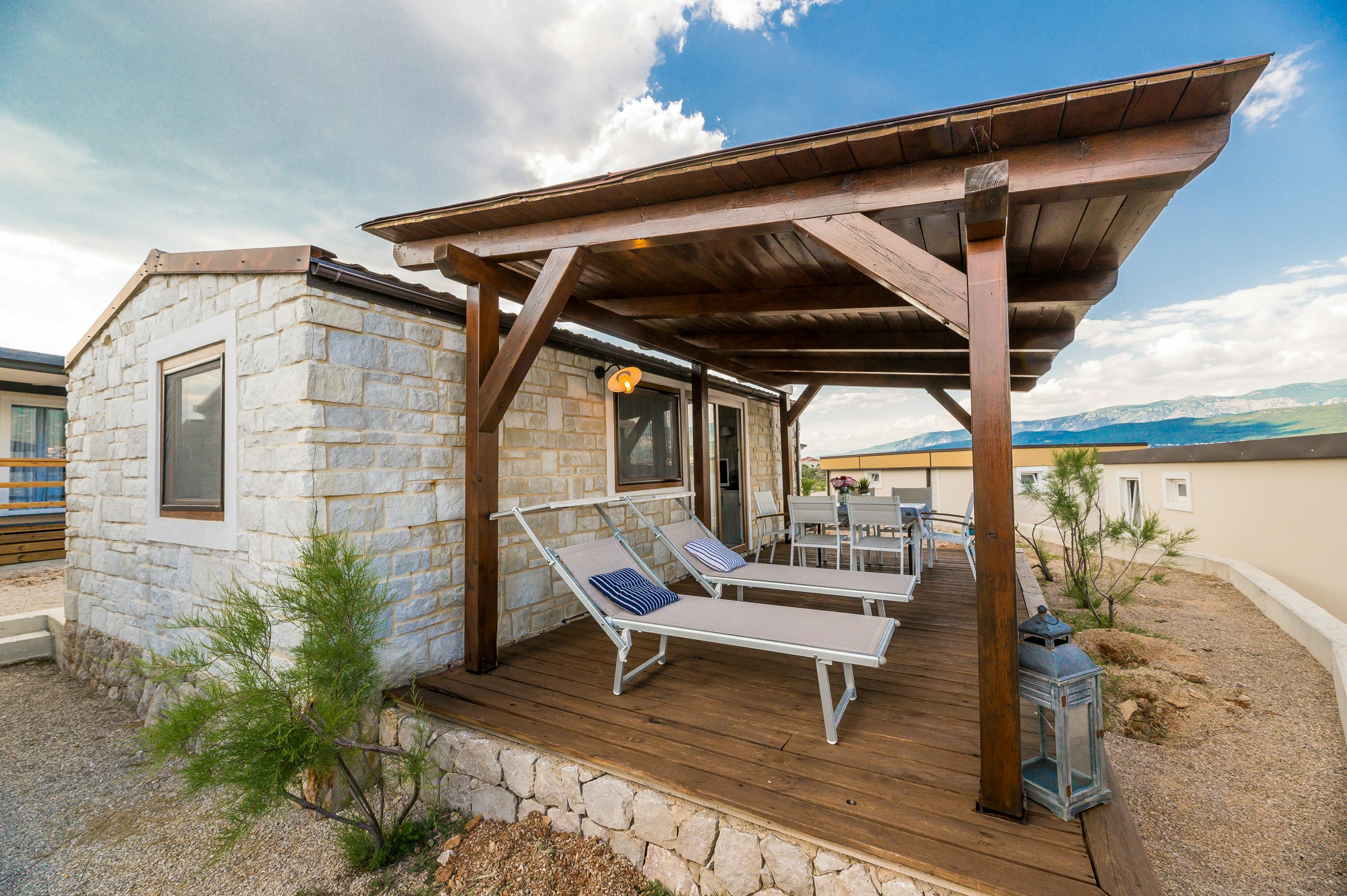 Camp Tiha Šilo - überdachte Terrasse mit Sitzmöglichkeiten einer Mediterranean Premium Mobilheim-Mietunterkunft