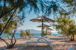 Camp Waterman Beach Village - Badestrand mit Liegestühlen und Sonnenschirmen
