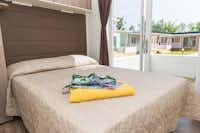 Campeggio Paradiso  - Doppelbett im Schlafzimmer eines Mobilheims