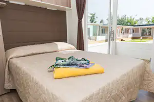 Campeggio Paradiso - Doppelbett im Schlafzimmer eines Mobilheims