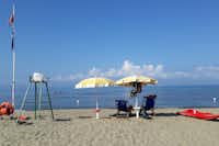 Campeggio Villaggio dei Pini  - Strand vom Campingplatz am Mittelmeer mit Sonnenschirmen und Liegestühlen