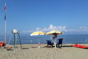 Campeggio Villaggio dei Pini - Strand vom Campingplatz am Mittelmeer mit Sonnenschirmen und Liegestühlen