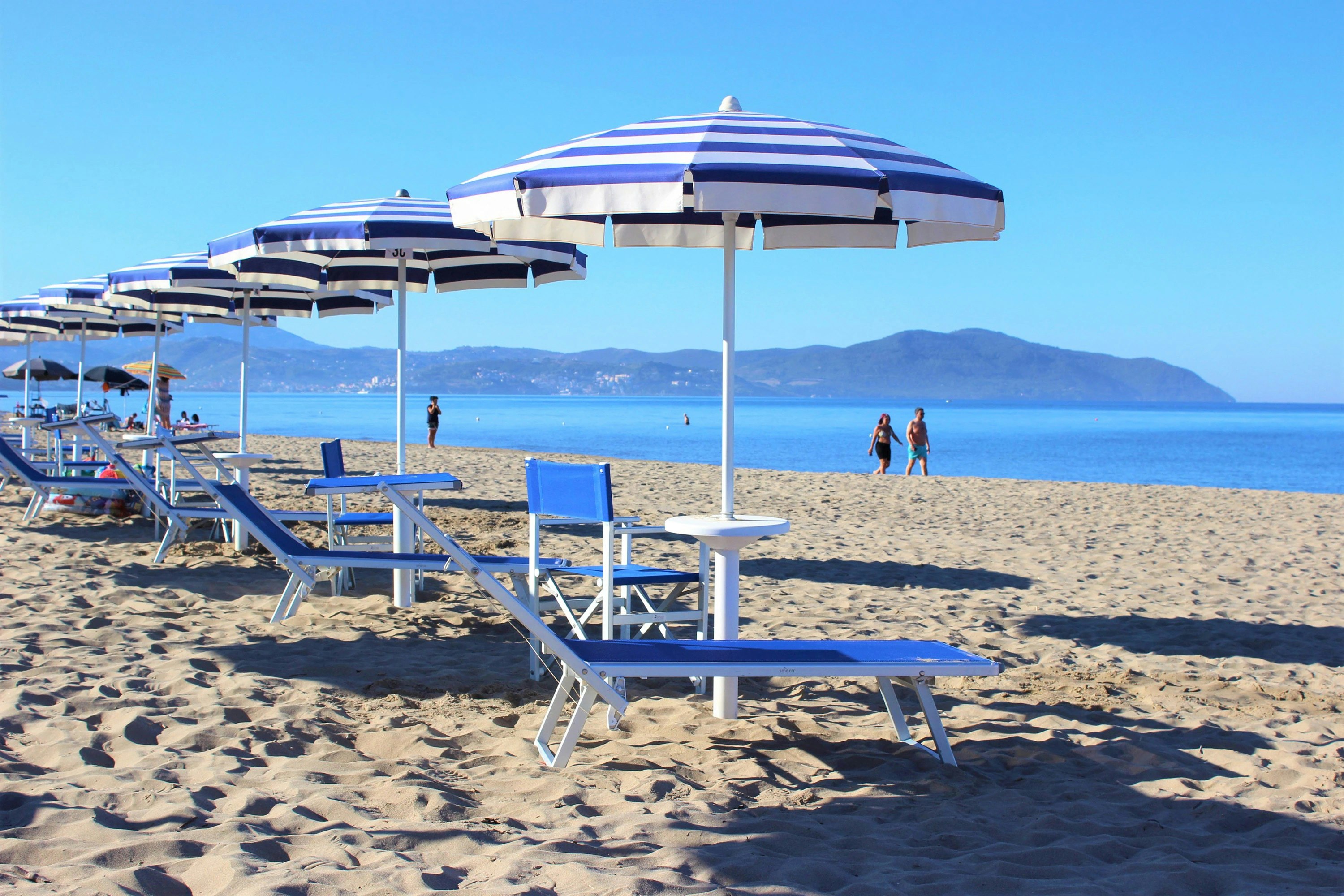 Campeggio Villaggio dei Pini - Blick vom Strand auf das Meer mit Sonnenliegen und Schirmen