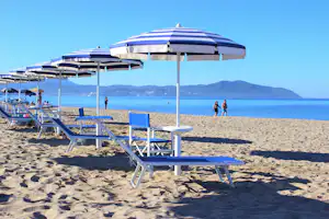 Campeggio Villaggio dei Pini - Blick vom Strand auf das Meer mit Sonnenliegen und Schirmen