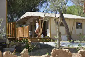 Campeggio Villaggio Torre del Porticciolo - Glamping Zelt mit Veranda auf dem Campingplatz zwischen Bäumen