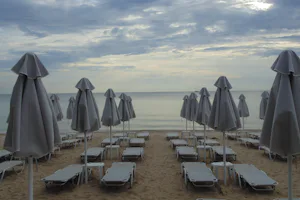 Camping A. Ouzouni Beach - Direkter Zugang vom Campingplatz zum Strand mit Liegestühlen und Sonnenschirmen