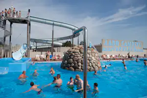 Großes Schwimmbecken auf dem Campingplatz Aabo Camping mit Wasserrutsche, Liegen und mehreren Schwimmern im Pool.