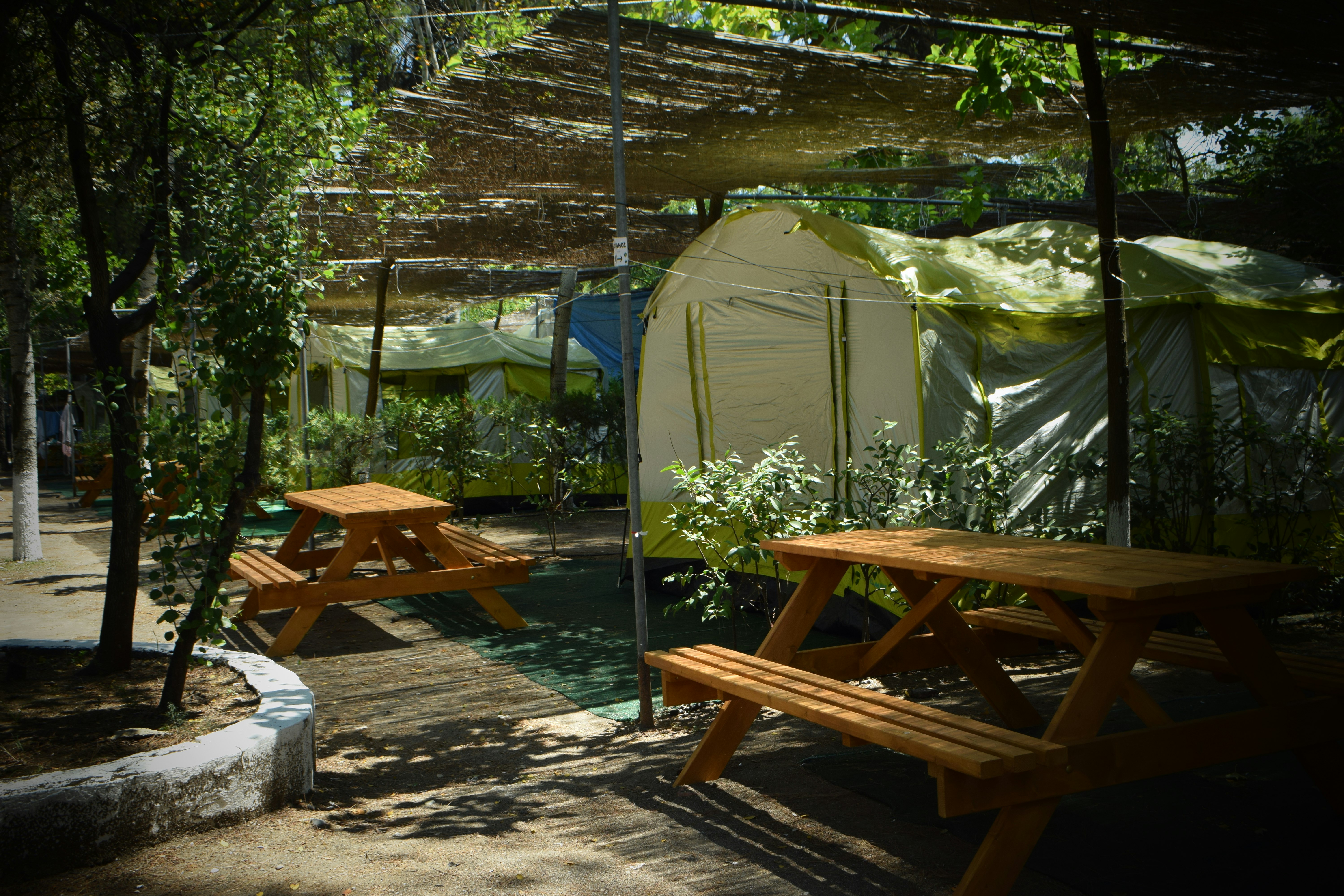Camping Agía Anna  -  Wohnwagen- und Zeltstellplatz auf dem Campingplatz im Schatten mit Picknicktischen