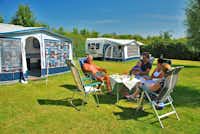 Camping Agri-Nova - Camper sitzen vor dem Wohnmobil in der Sonne
