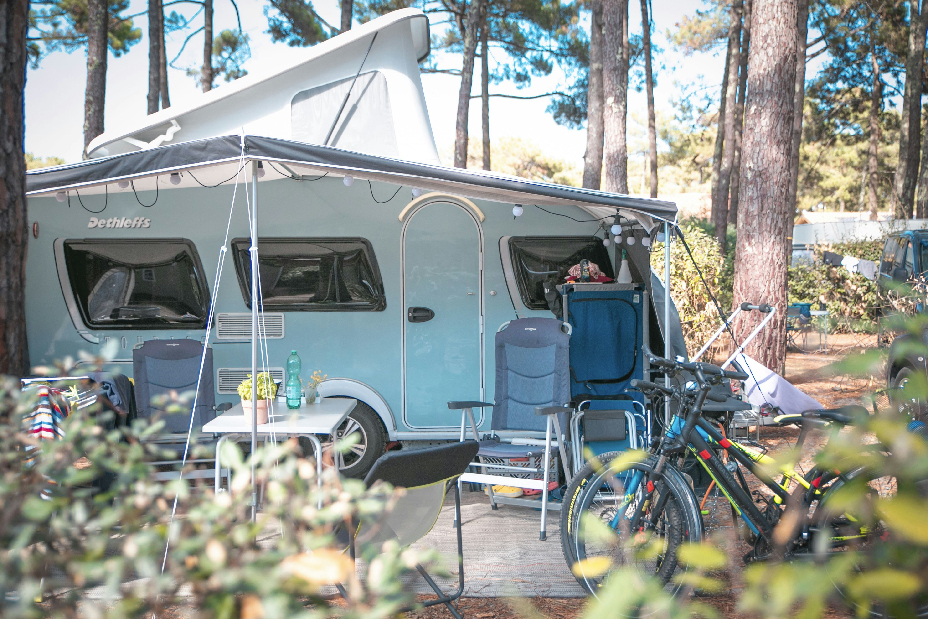 Camping & Spa Airotel L'Océan - Standplatz mit Wohnwagen unter schattenspendenden Bäumen