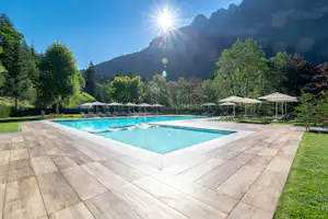 Camping Alleghe - Swimmingpool mit Liegestühlen und Sonnenschirmen am Rand
