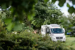Camping am Deich - Nordsee - Blick auf einen Stellplatz zwischen den Bäumen