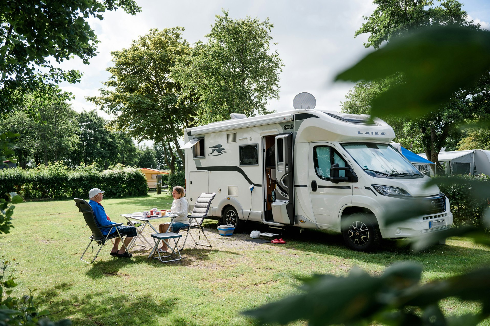 Camping am Deich - Nordsee - Gäste entspannen sich auf ihrem Wohnwagenstellplatz