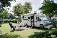 Camping am Deich - Nordsee - Gäste entspannen sich auf ihrem Wohnwagenstellplatz