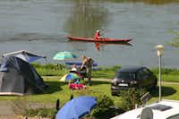 Camping am Fluss - Stellplatz mit Zelt und essender Familie, im Hintergrund ein Kanufahrer in der Weser