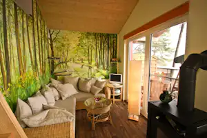 Camping am Schwielochsee - Innenraum eines Ferienhauses mit Sofa und Kamin