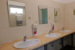 Camping Am Treidlerweg - Waschbecken und Spiegel im Innenraum des Sanitärbereichs