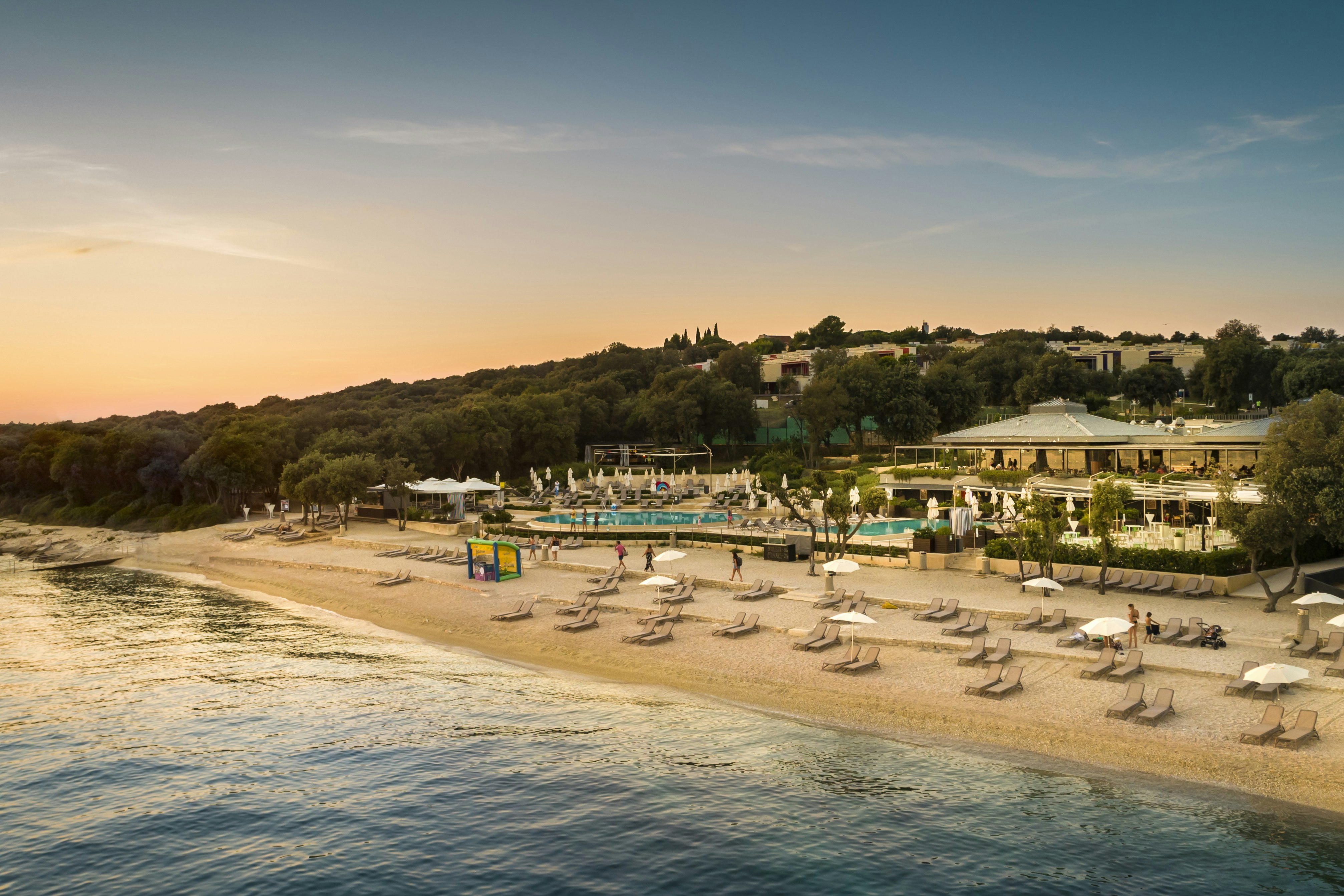 Camping Amarin - Blick auf den Strand mit Liegestühlen und Sonnenschirmen