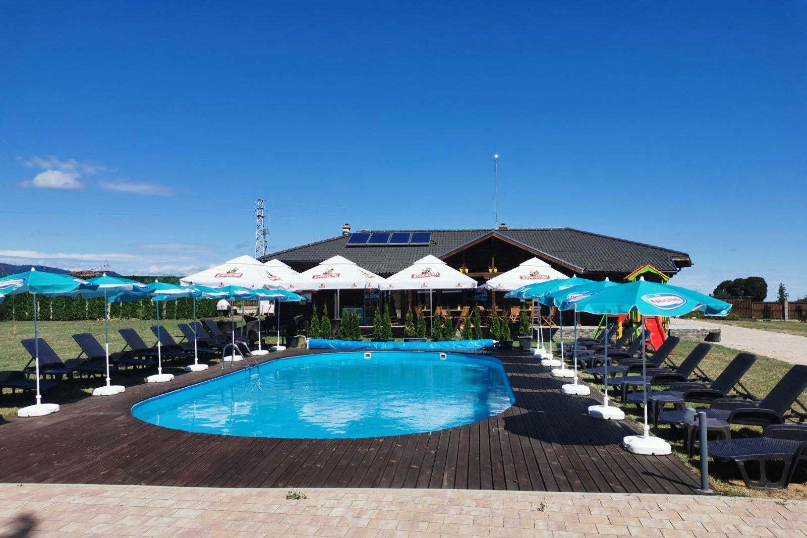 Camping Amazing Village - Freibad mit Liegestühlen auf dem Campingplatz