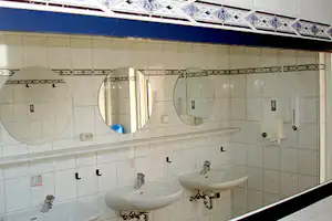 Camping Ampersee - Sanitärgebäude mit Waschbecken, Spiegel, Toiletten und Duschen