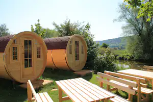 Camping An der Altmühl - Mobilheime vom Campingplatz mit Picknicktischen und Blick auf den Fluss