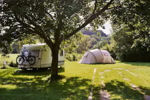 Camping an der Rudelsburg - Wohnwagen und Zelt auf dem Stellplatz vom Campingplatz auf grüner Wiese