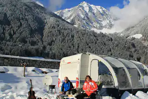 Camping Antholz - Gäste vor ihrem Wohnmobil Im Schnee mit Blick auf die Berge