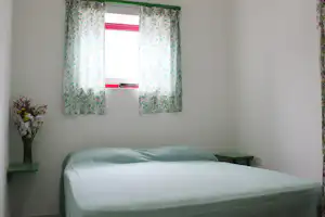 Camping Arcobaleno - Schlafzimmer in einem Bungalow mit Bett