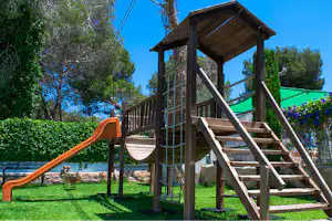 Camping Arena Blanca - Kletterburg des Kinderspielplatzes mit Rutsche