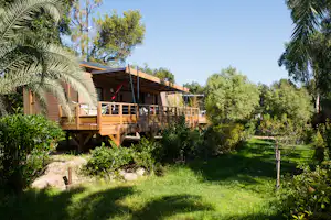 Camping Arinella Bianca - Glamping Mobilheim auf Stelzen mit Veranda im Grünen