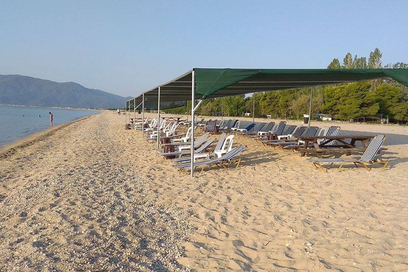 Camping ASPROVALTAS BEACH - Sonnenliegen am Strand unter einem Pavillon