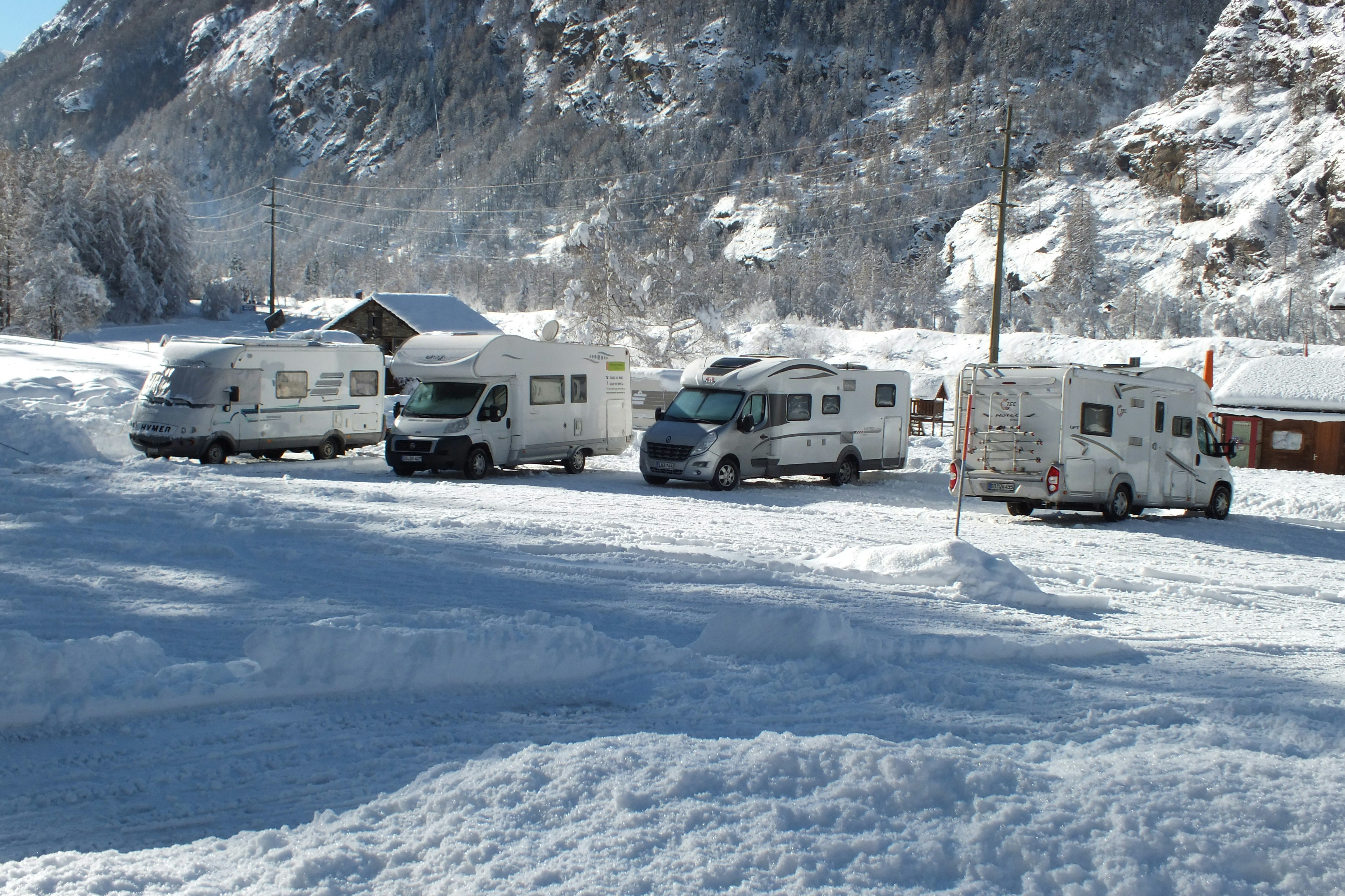 Camping Attermenzen -  Wohnwagenplatz im Schnee auf dem Campingplatz mit Blick auf die Berge