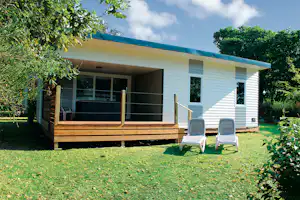 Camping Au Bocage du Lac - Mobilheim vom Campingplatz mit Veranda und Liegestühlen auf grüner Wiese