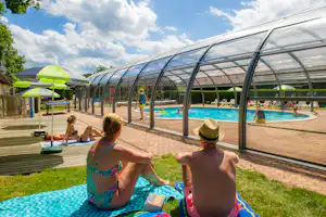 Camping Au Clos de la Chaume - Camper auf der Liegewiese vor dem überdachten Swimmingpool