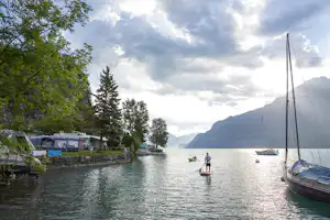 Camp au Lac - Die Stellplätze am See mit den Bergen im Hintergrund