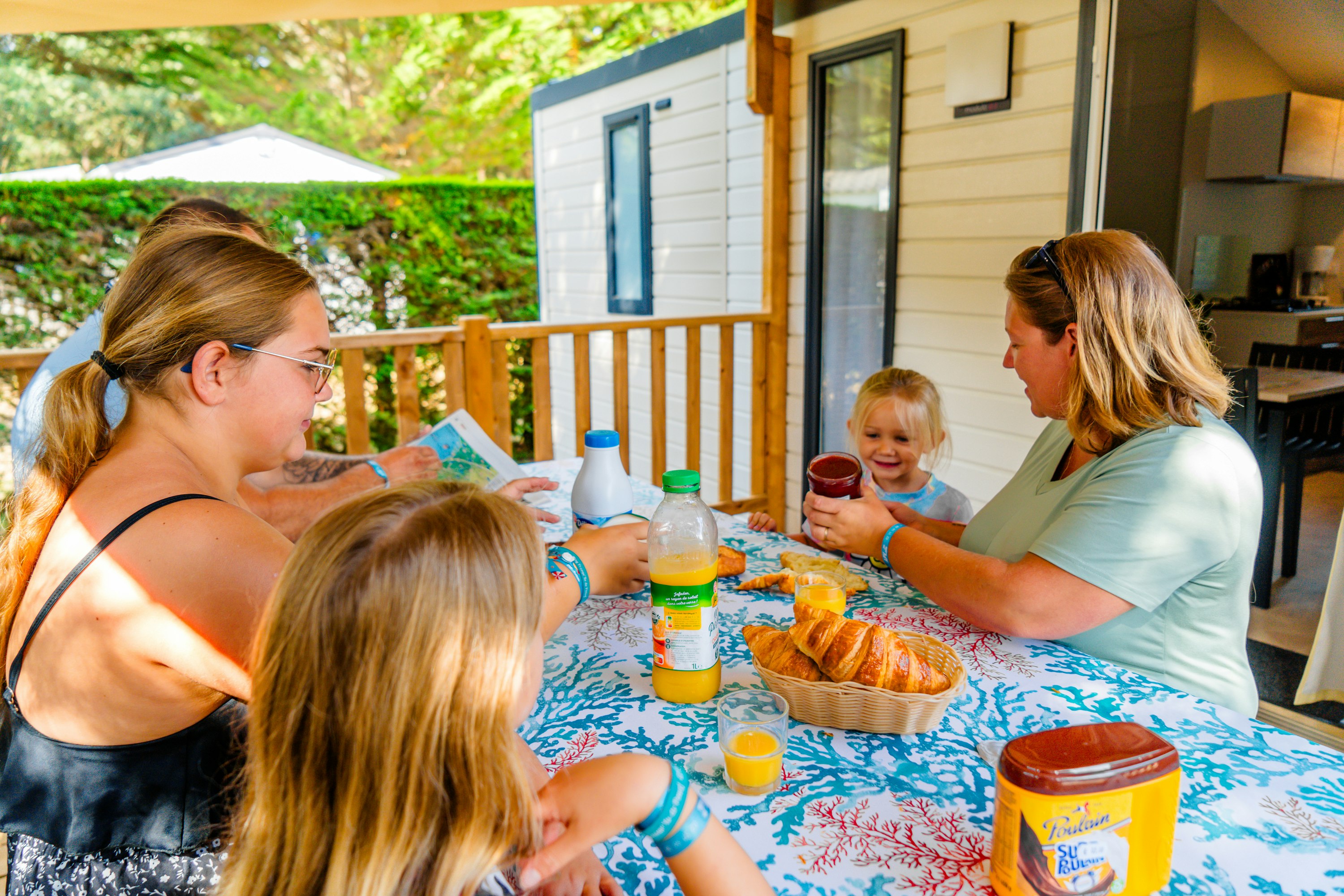 Camping Au Val de Loire en Ré  CAMPING AU VAL DE LOIRE EN RÉ - Familie beim gemeinsamen Frühstücken auf der Terrasse eines Mobilheims