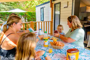 Camping Au Val de Loire en Ré CAMPING AU VAL DE LOIRE EN RÉ - Familie beim gemeinsamen Frühstücken auf der Terrasse eines Mobilheims