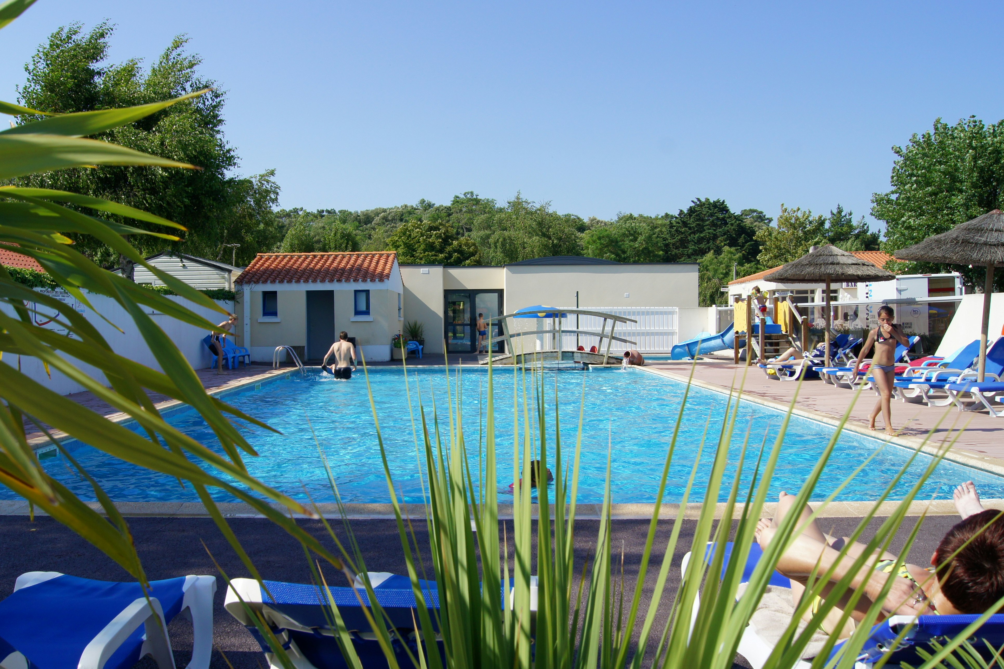Camping Aux Coeurs Vendéens  - Pool im Freien mit Liegestühlen und Sonnenschirmen