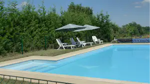 Camping Aux Mêmes - Pool mit Liegestühlen und Sonnenschirmen auf dem Campingplatz