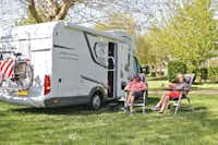 Camping Aux Rives du Soleil - Gäste entspannen vor ihrem Stellplatz auf der Wiese
