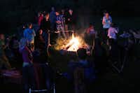 Camping Aux Sources de Lescheret - Gäste grillen auf dem Campingplatz an der Feuerstelle.