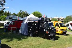 Camping Aux Vernes - Mehrere motorisierte Dreiräder auf einem Stellplatz