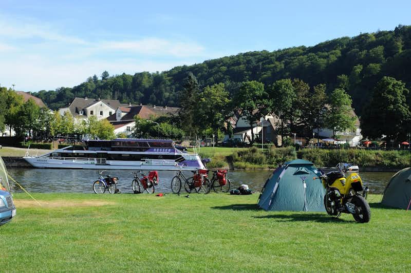 Camping Bad Karlshafen - grasbewachsenes Flussufer mit Zelten und Motorrädern