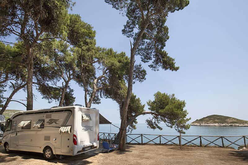 Camping Baia di Campi - Wohnmobil zwischen Bäumen mit dem adriatischen Meer im Hintergrund