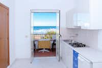 Camping Baia San Nicola - Innenraum eines Apartments mit Kochnische und Balkon mit Meerblick