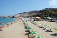 Camping Baia San Nicola - Strand des Mittelmeers mit Liegestühlen und Sonnenschirmen