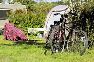 Camping Baie de Térénez - Fahrräder vor einem Standplatz im Grünen